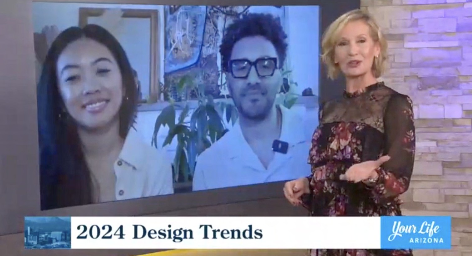 A television segment in progress: a host in a floral lace dress gestures toward a large screen showing two La Union Studio team members on a video call, with a lower-third graphic reading "2024 Design Trends" and the Your Life Arizona logo.