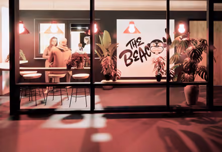 Architectural rendering of a storefront at night with red lighting, plants, and a sign reading 'The Beacon
