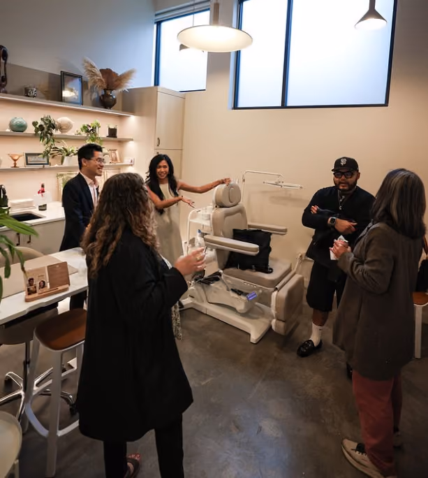 Guests chatting and mingling inside a studio space during the open house