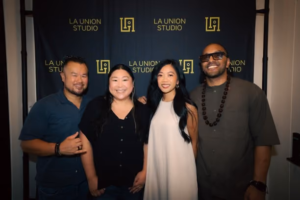 Four people smiling together at the open house celebration