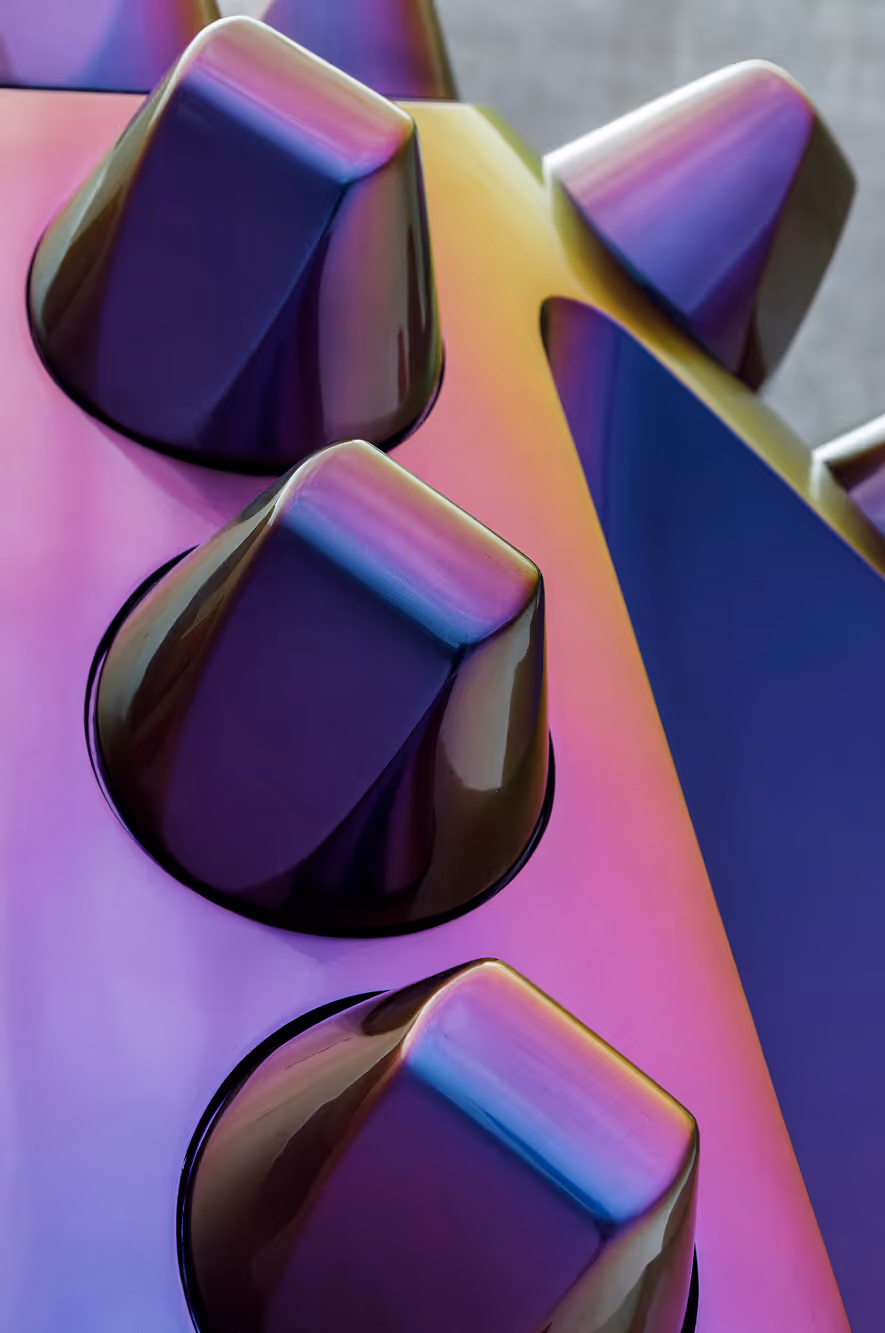 Nærbillede af guitarknapper med reflekterende overflade i lilla og blå nuancer.