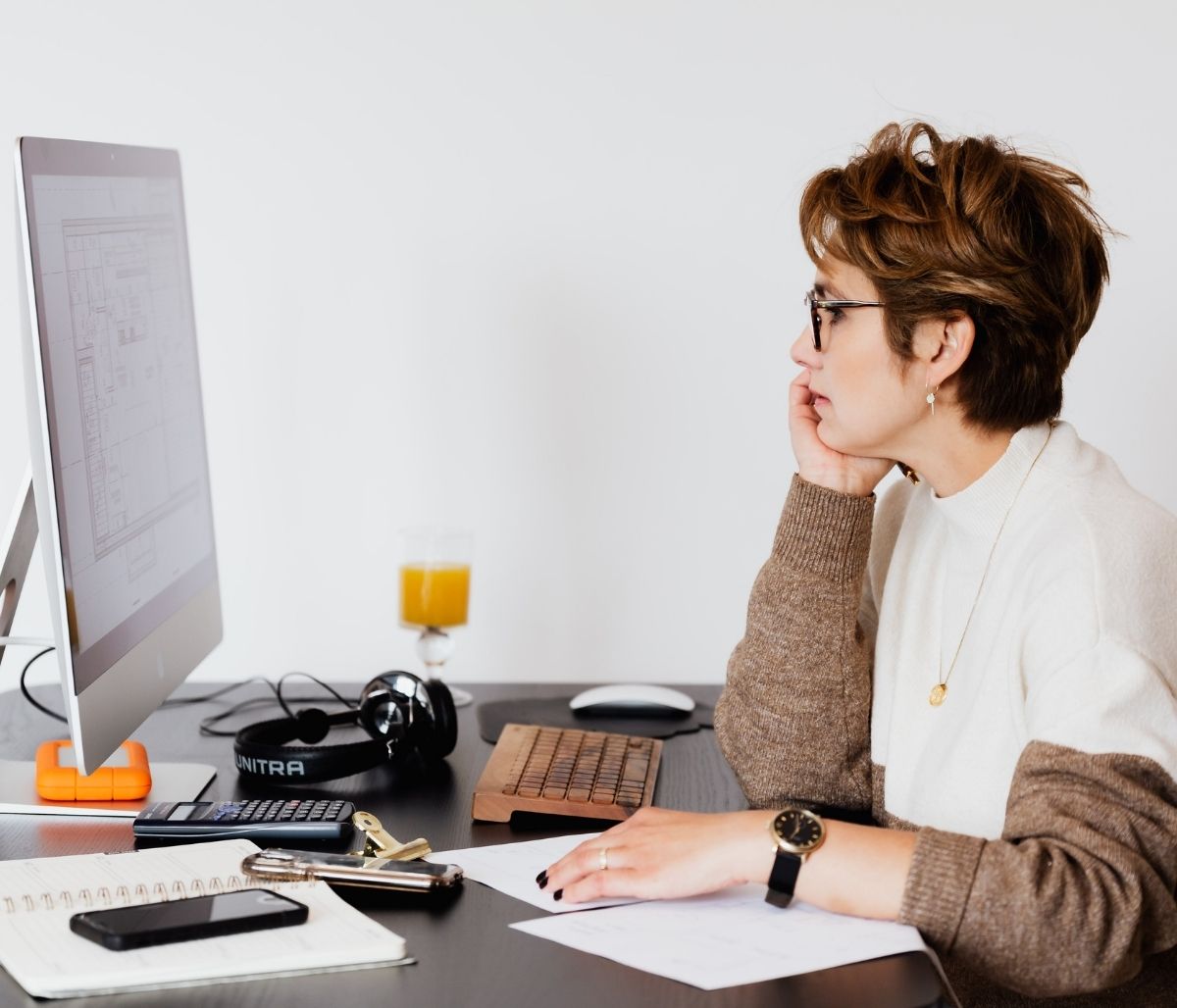 Woman sitting at desk looking at computer screen