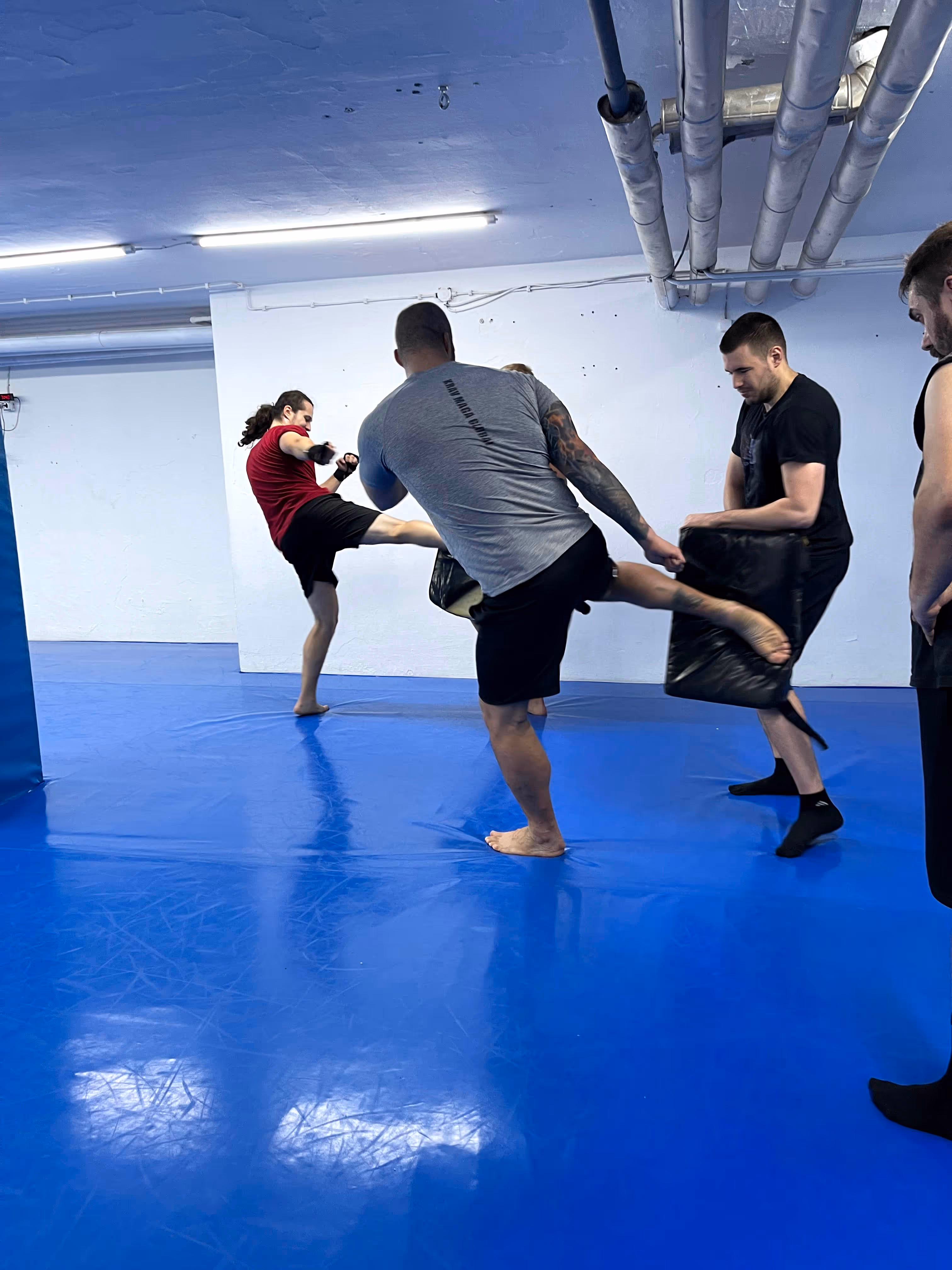 Trening u sali, trener pokazuje šut nogom