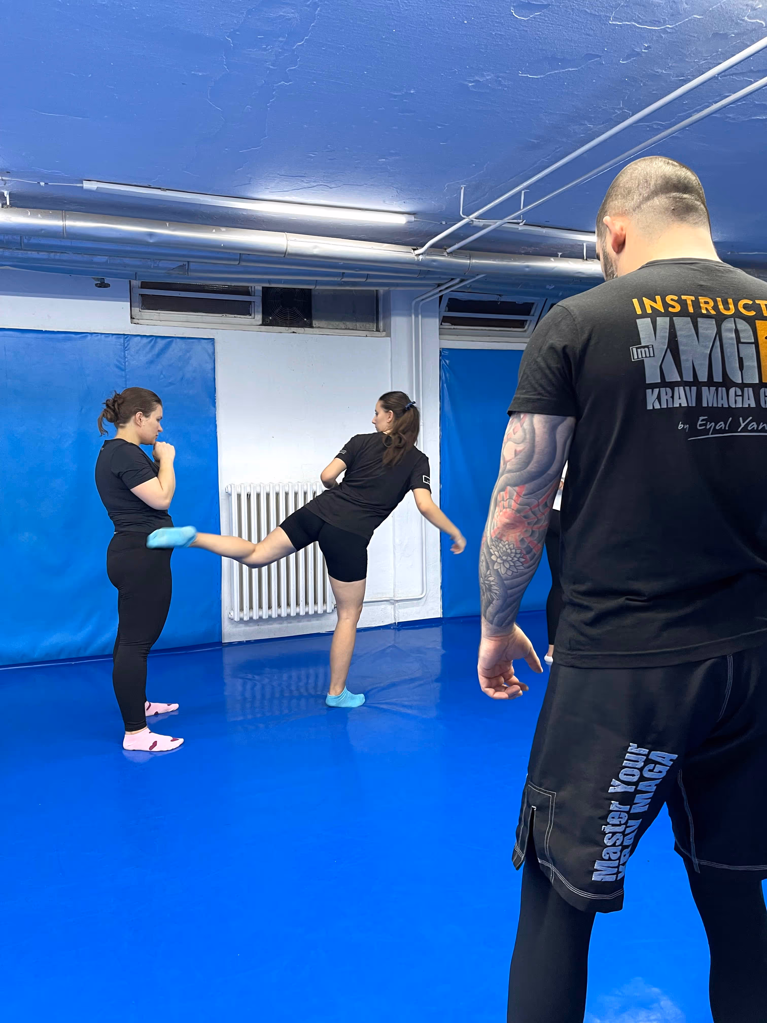 Trening u sali, trener posmatra tehniku kako se izvodi