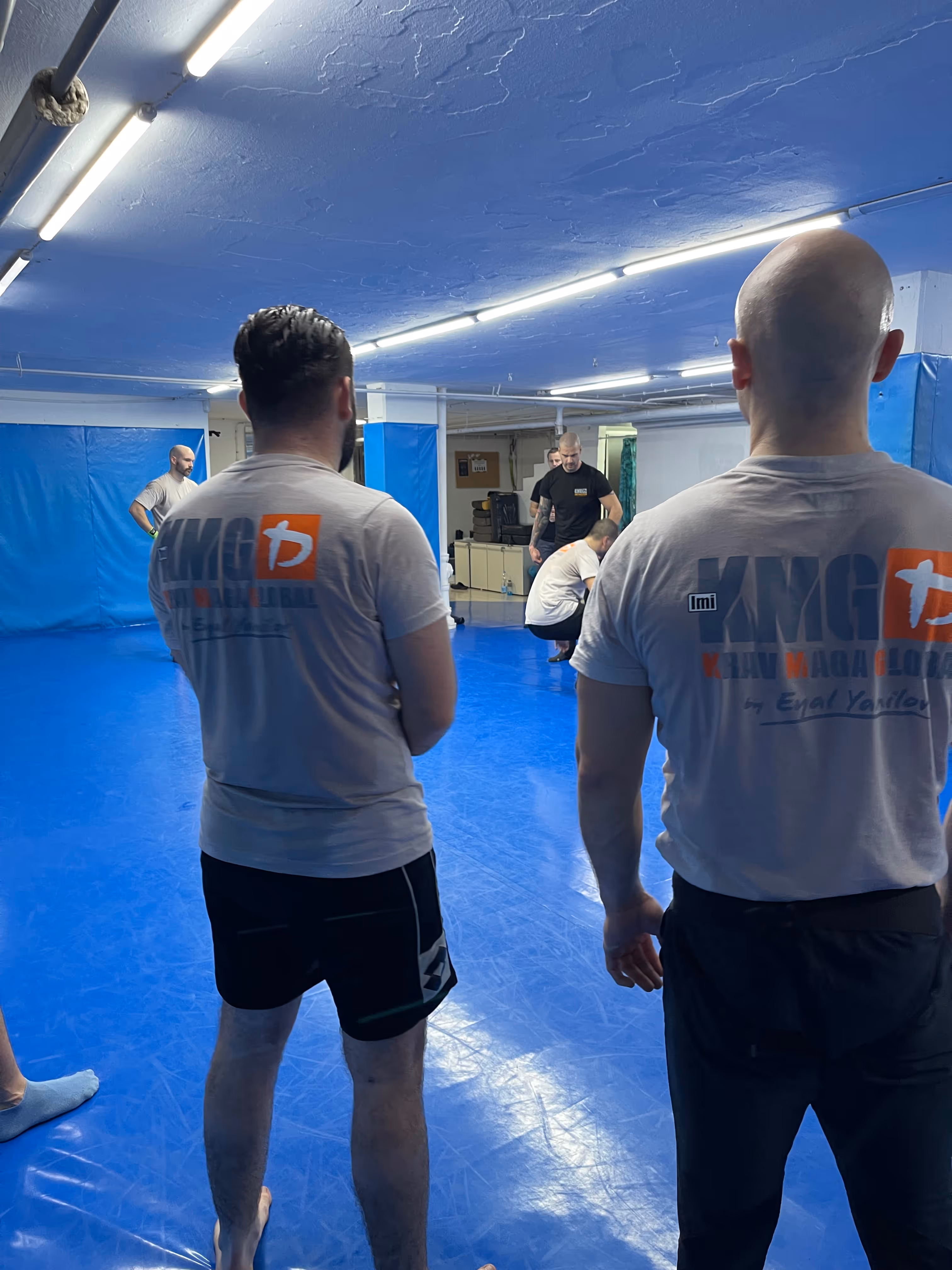 Polaznici Krav Maga treninga demonstriraju tehnike tokom testiranja za P nivo u sali, pod nadzorom instruktora