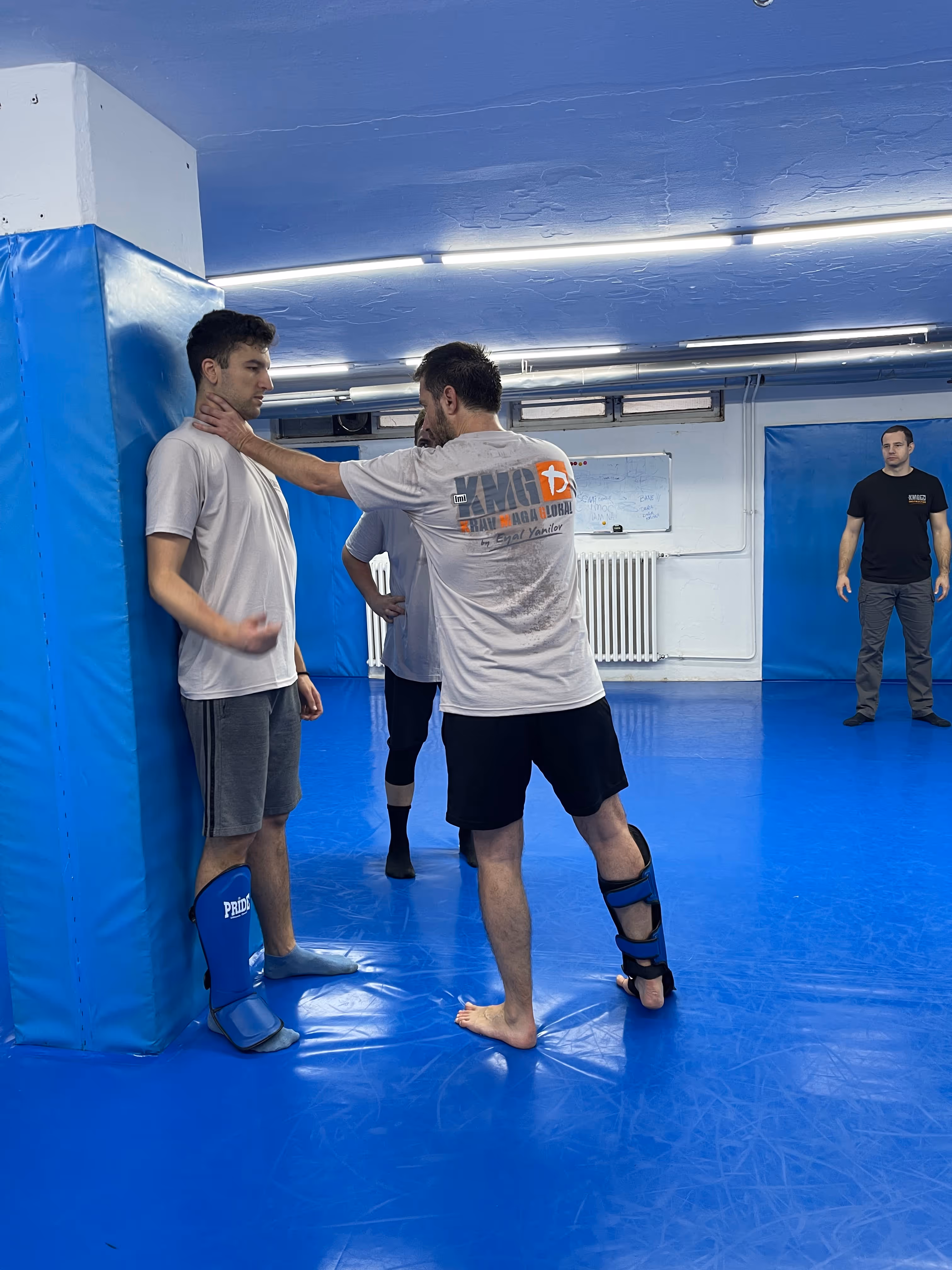 Polaznici Krav Maga treninga demonstriraju tehnike tokom testiranja za P nivo u sali, pod nadzorom instruktora