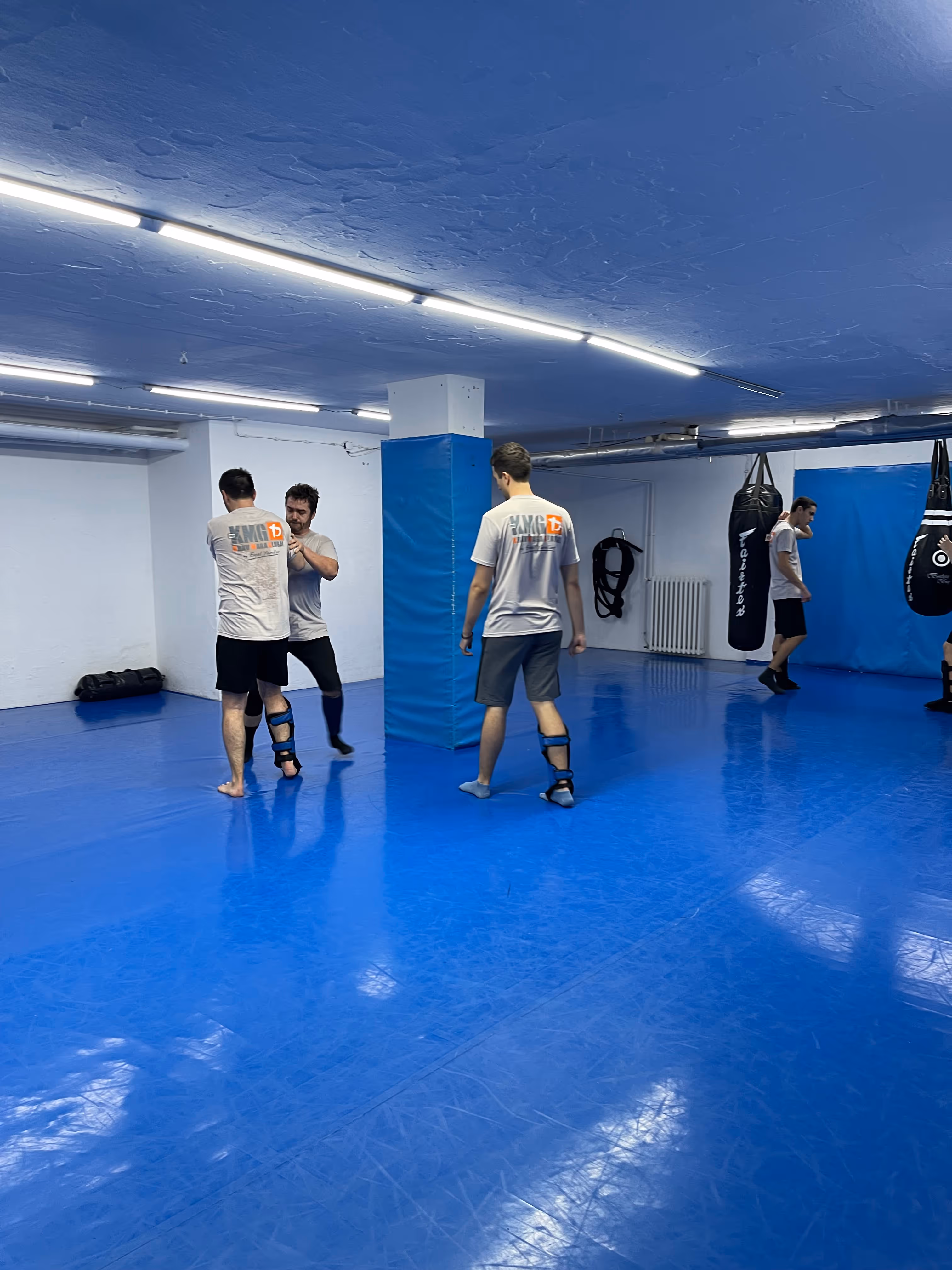 Polaznici Krav Maga treninga demonstriraju tehnike tokom testiranja za P nivo u sali, pod nadzorom instruktora