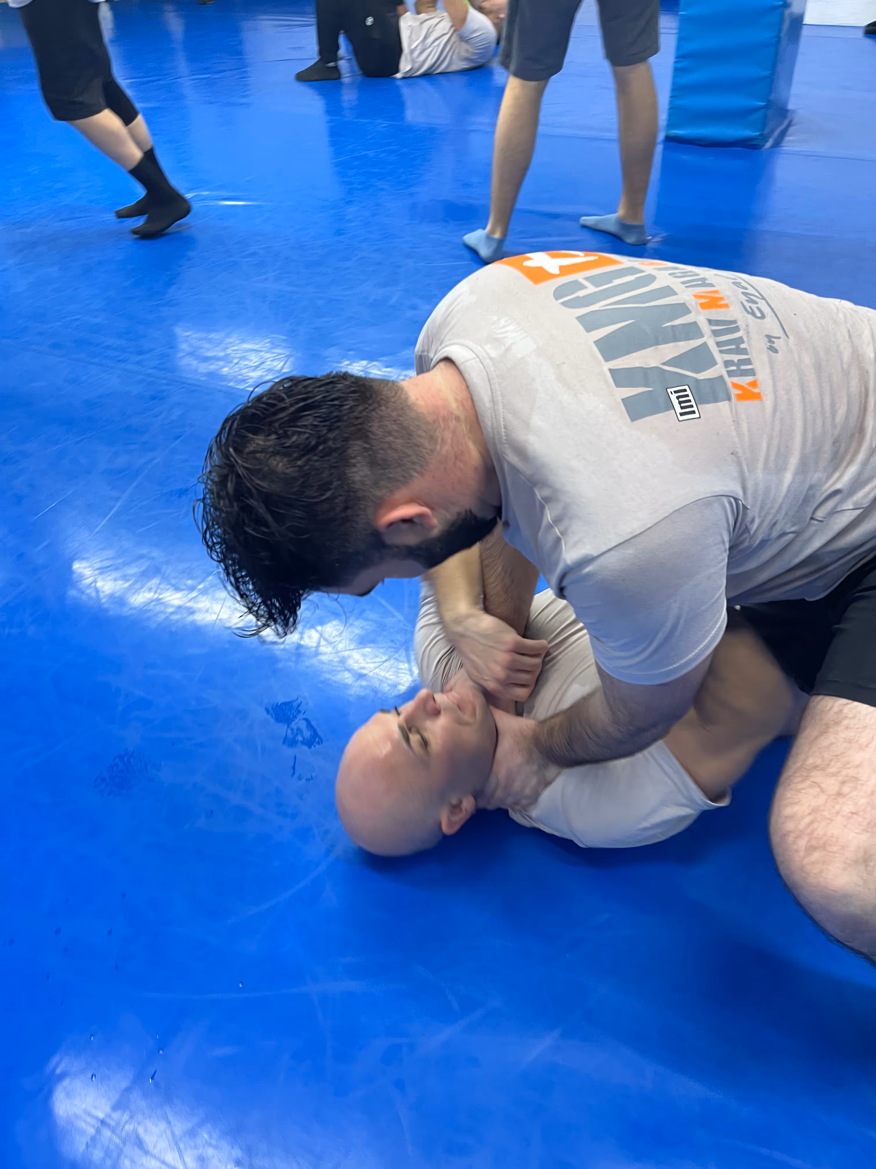 Polaznici Krav Maga treninga demonstriraju tehnike tokom testiranja za P nivo u sali, pod nadzorom instruktora