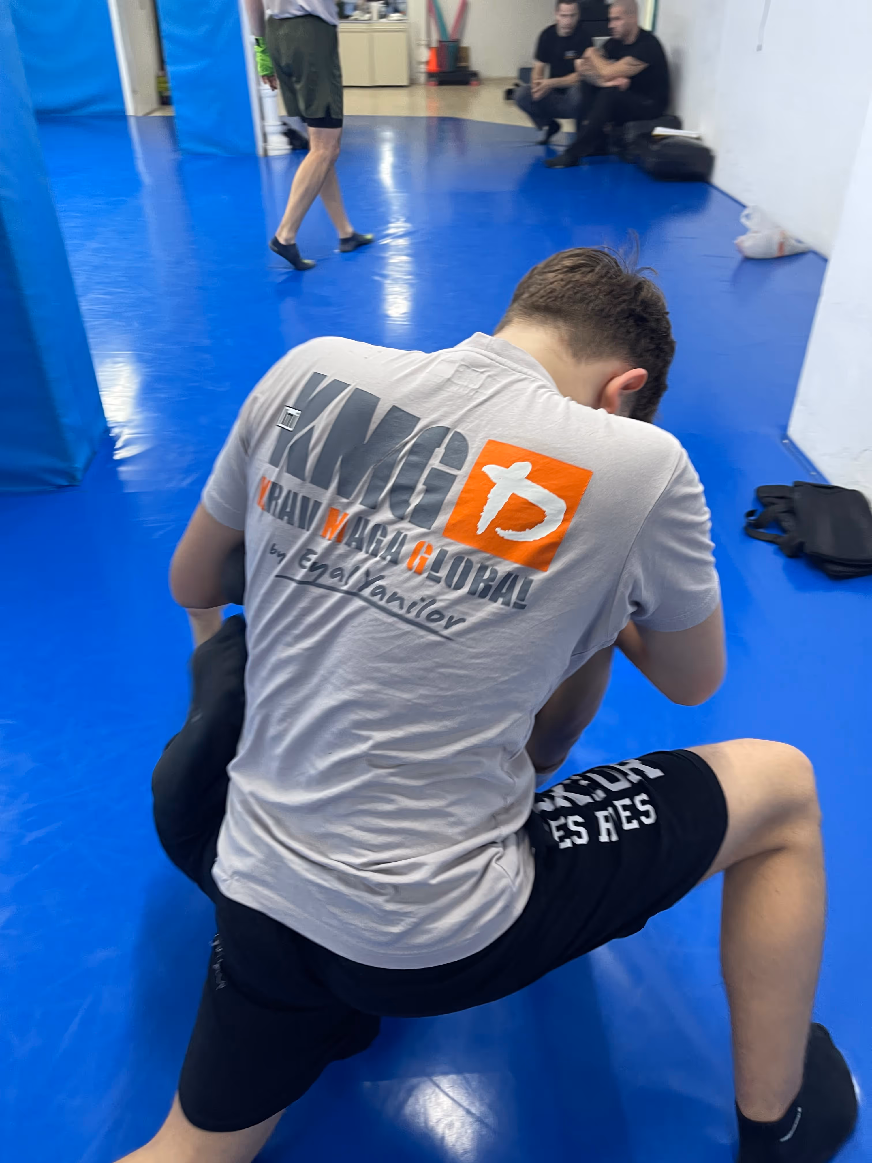 Polaznici Krav Maga treninga demonstriraju tehnike tokom testiranja za P nivo u sali, pod nadzorom instruktora