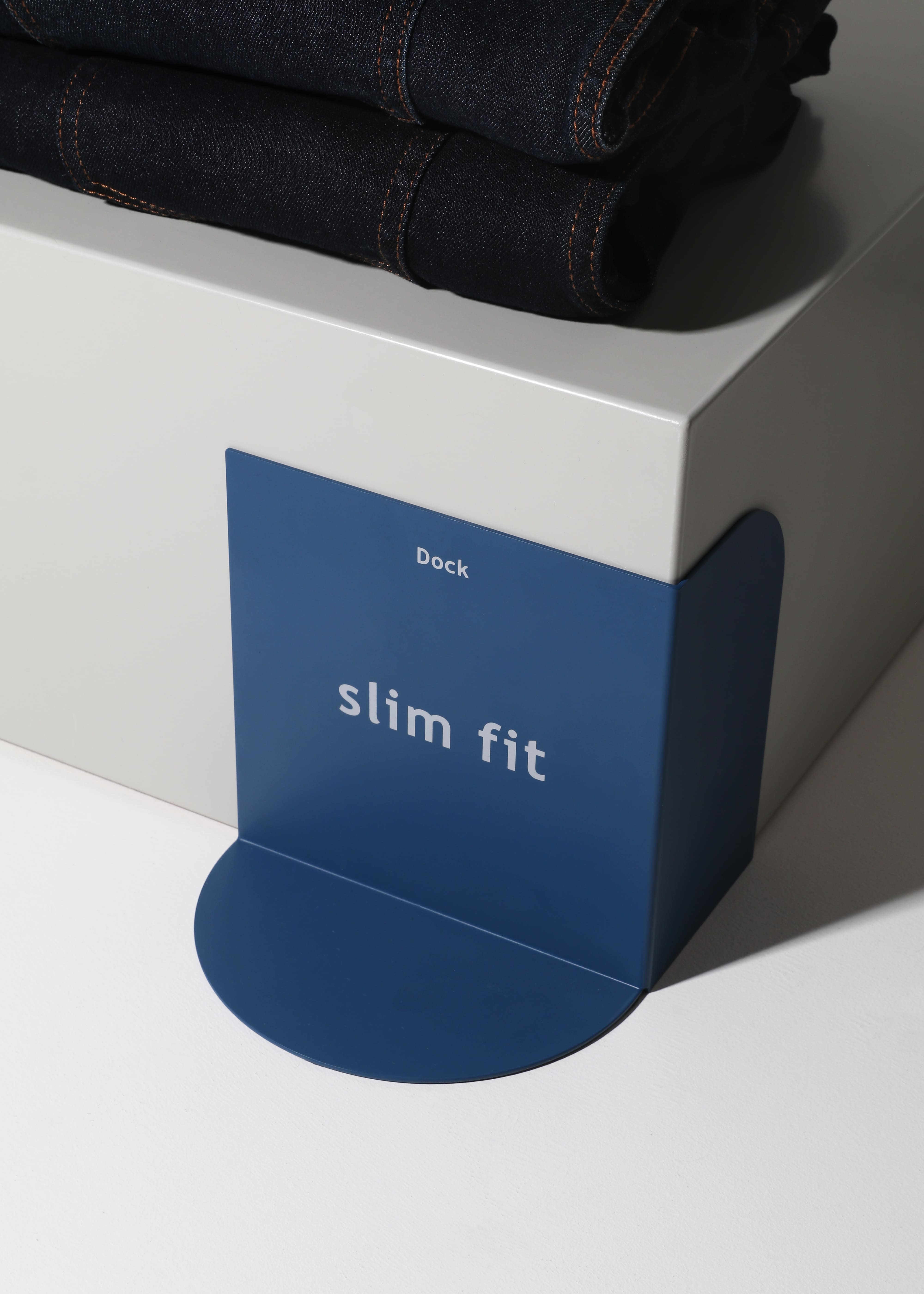 Slim Fit retail signage promoting tailored-fit denim jeans in a fashion store display.