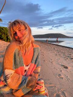 Two people kayaking on a calm lake with mountains in the background.