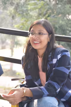 Two people kayaking on a calm lake with mountains in the background.