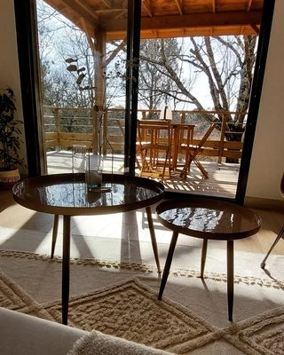 tables basses gigogne avec tapis type bali dans un gîte en bois sur pilotis