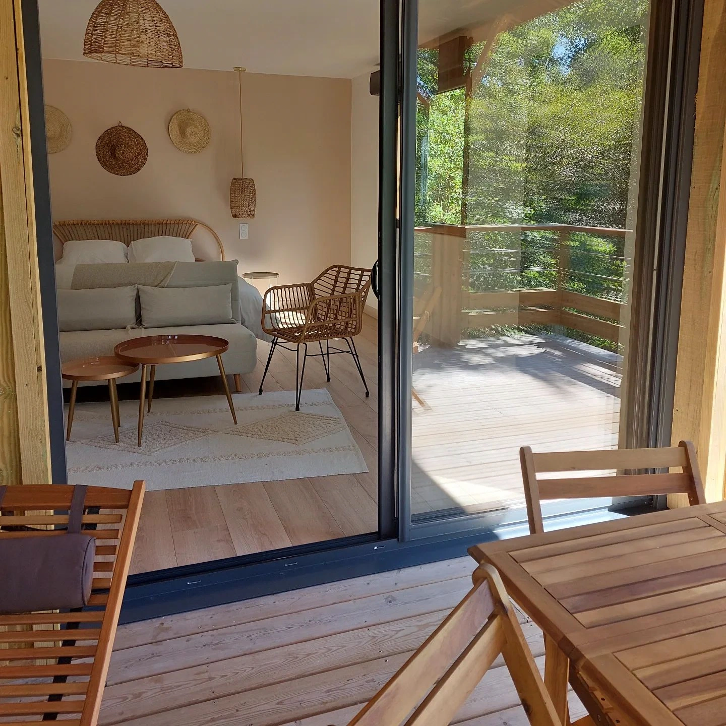 terrasse en bois d'un gîte sur pilotis avec vue sur le séjour