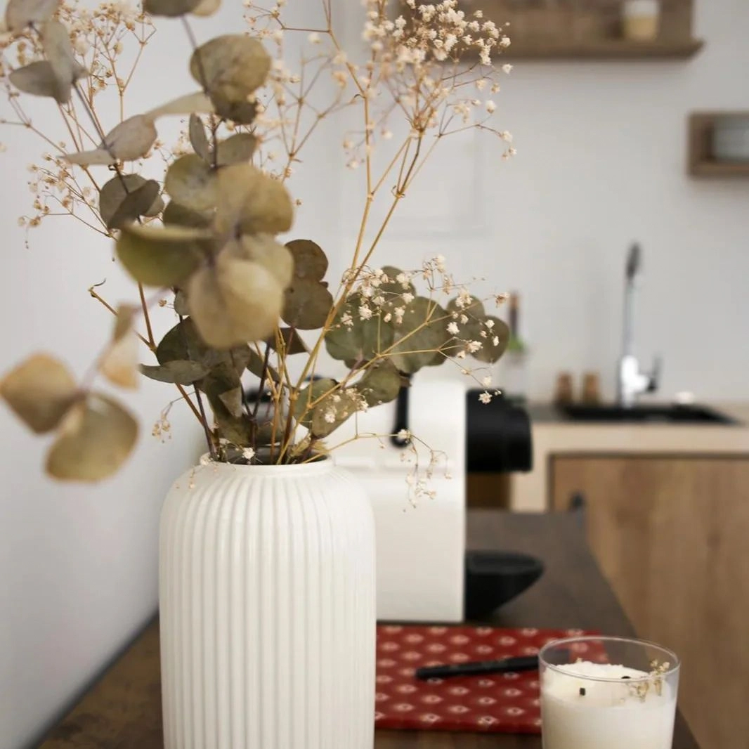 zoom sur un pot de fleur séchées dans une cuisine type bali
