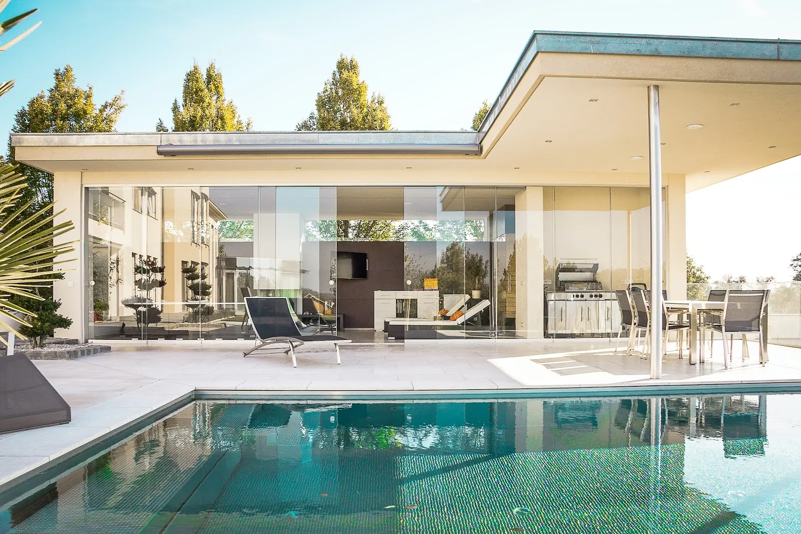 Behind the glass of a big house next to a swimming pool