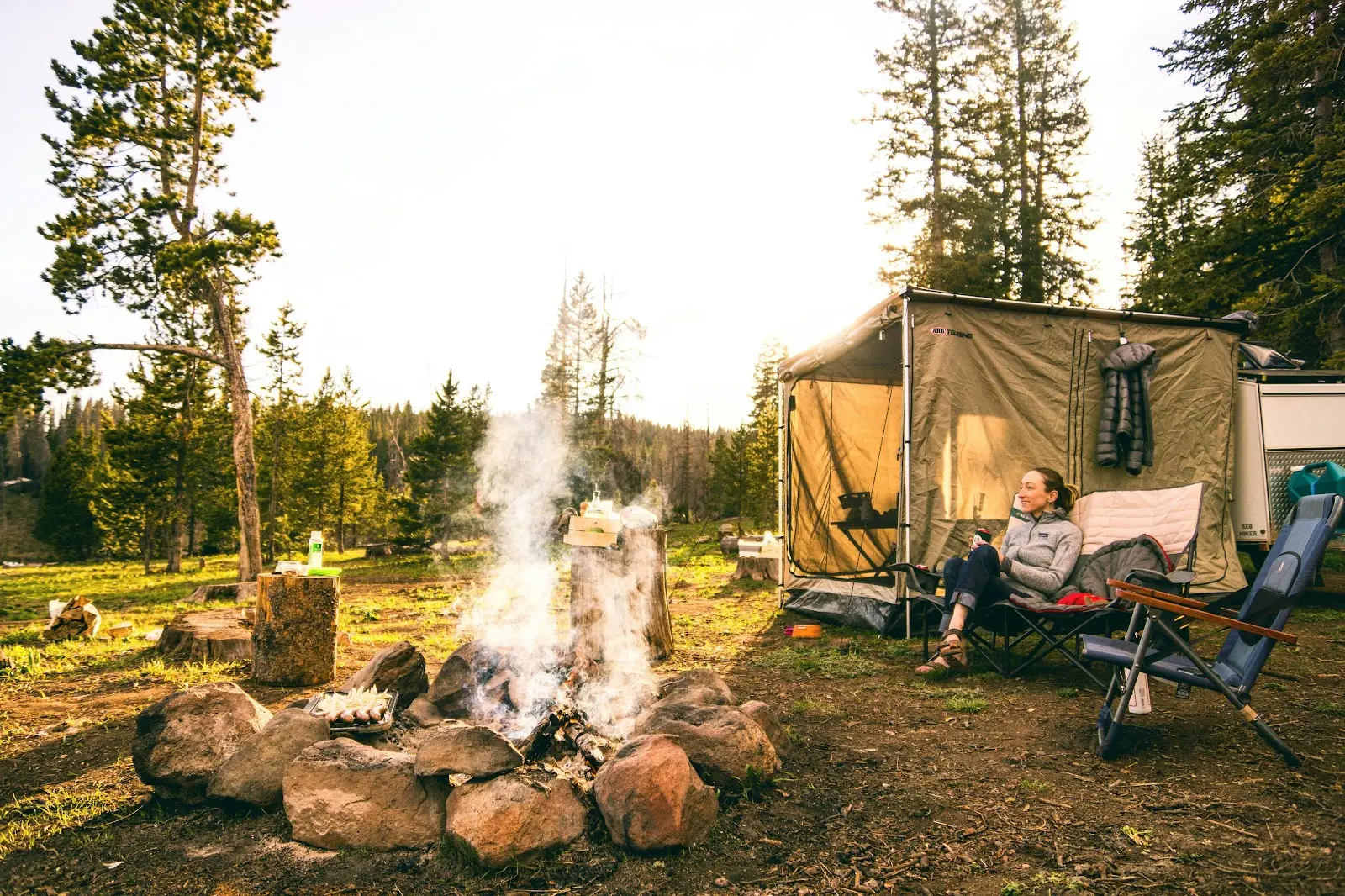 Fire smoke on logs surrounded by trees