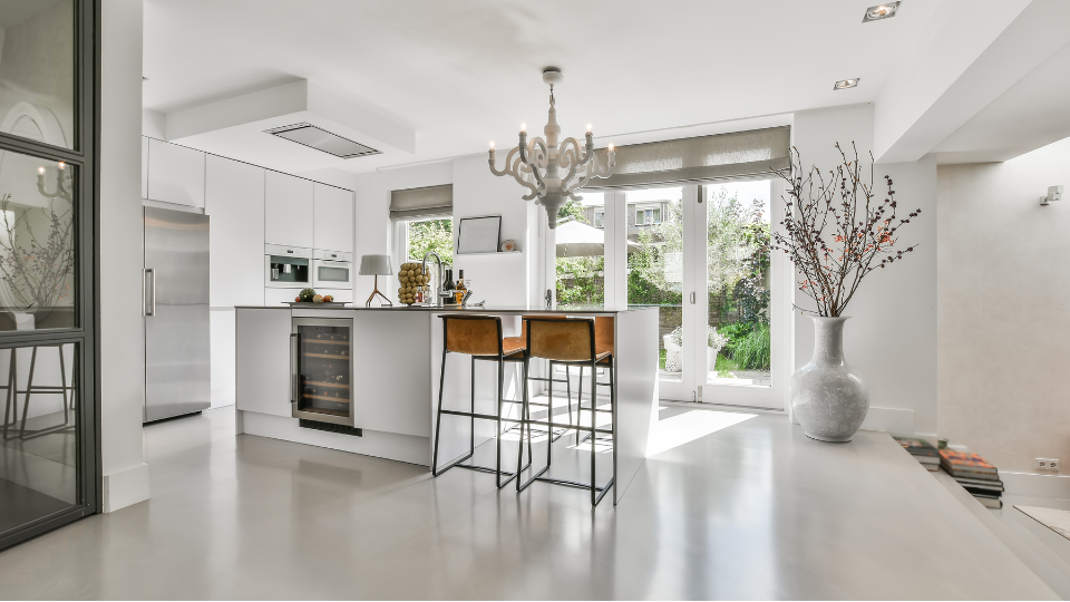 A modern kitchen with stainless steel appliances and a chandelier