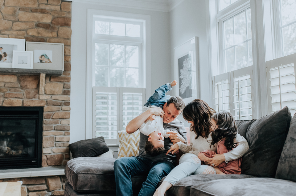 A family sitting on a couch in front of a fireplace