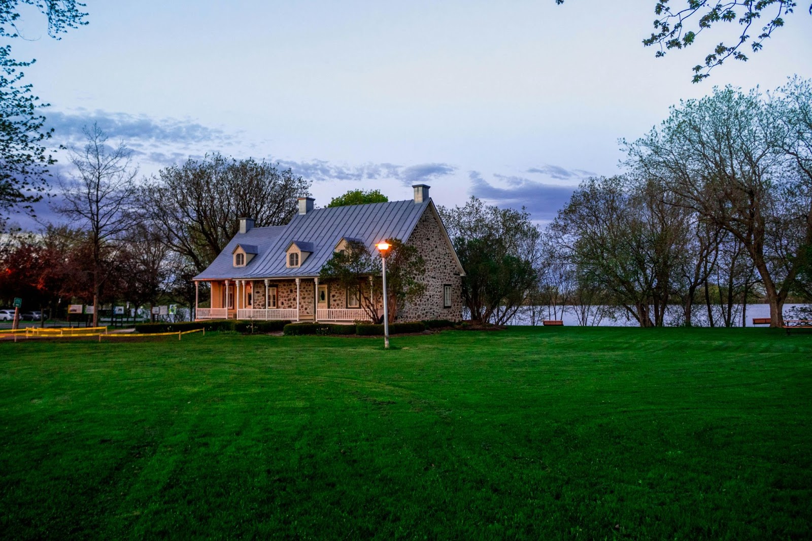 A stone cottage on a lake after sunset