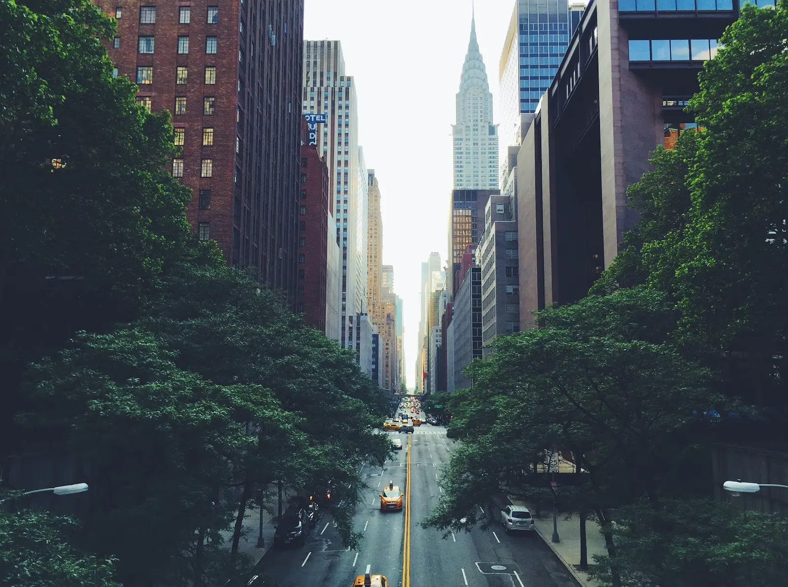 Cars driving on a street in between buildings