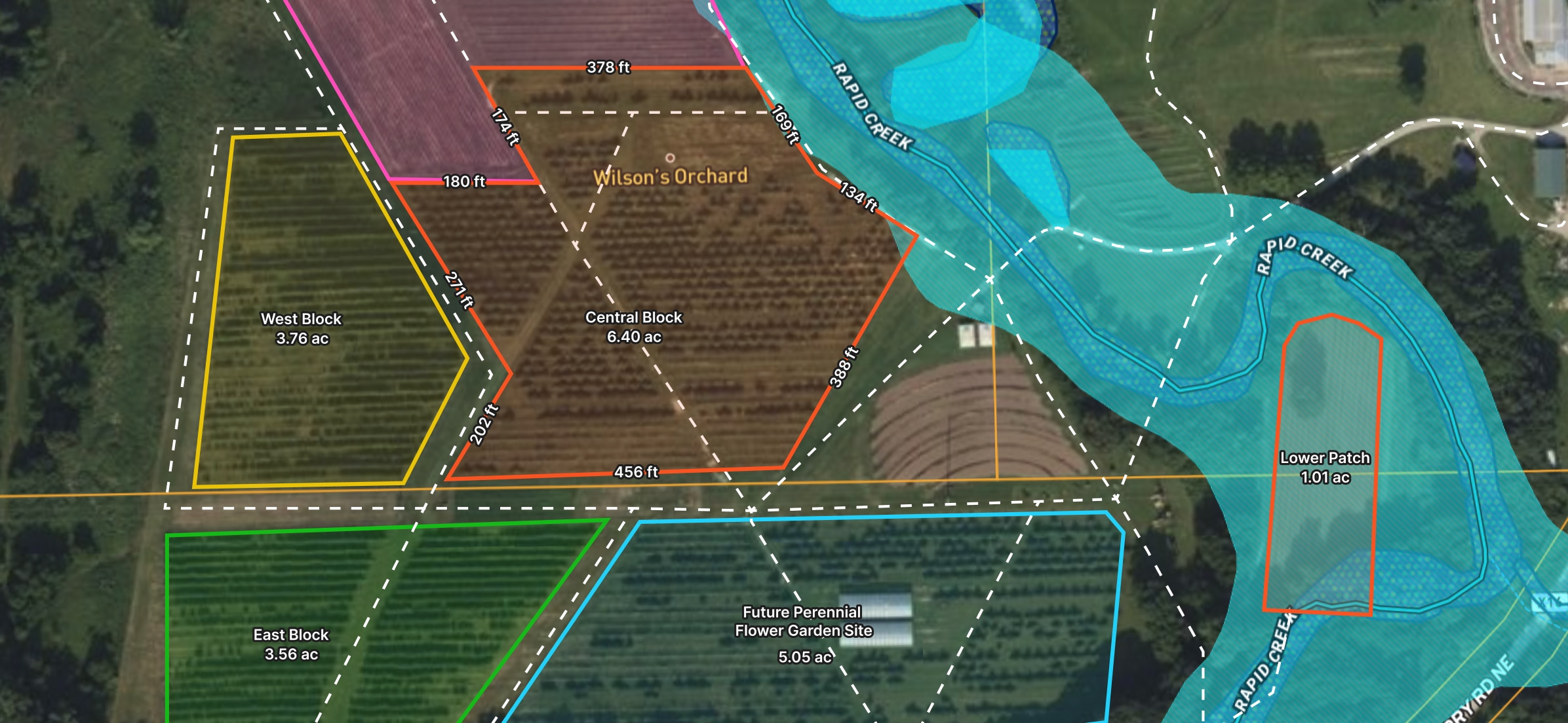 Aerial map of Wilson's Orchard, showing various sections outlined in different colors. Labeled areas include West Block, East Block, Central Block, Lower Patch, and a future flower garden site. Blue areas depict water features.