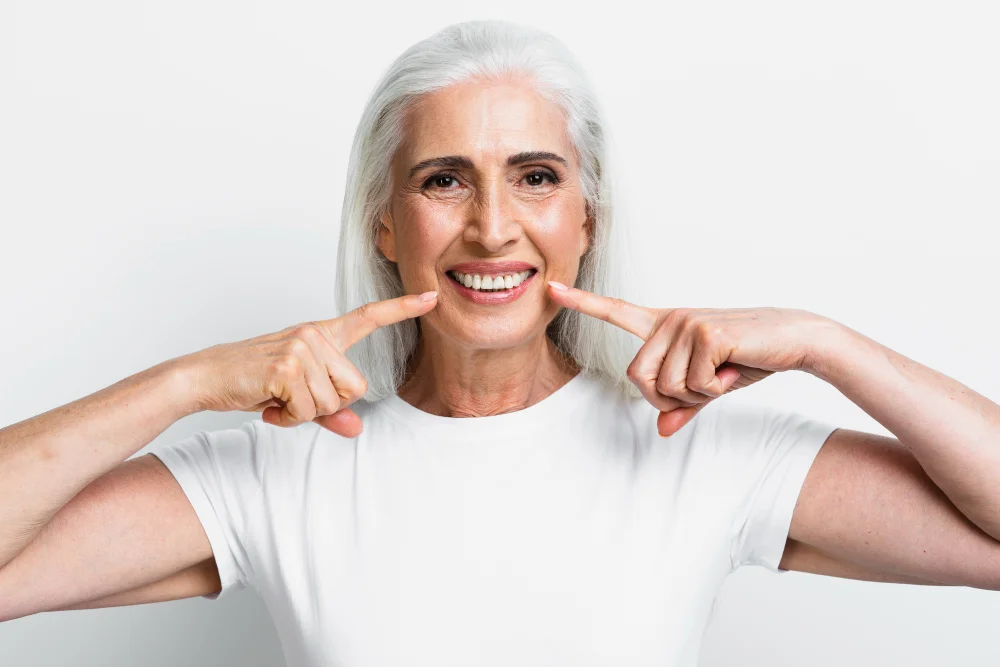 An older woman pointing at the camera with her finger.