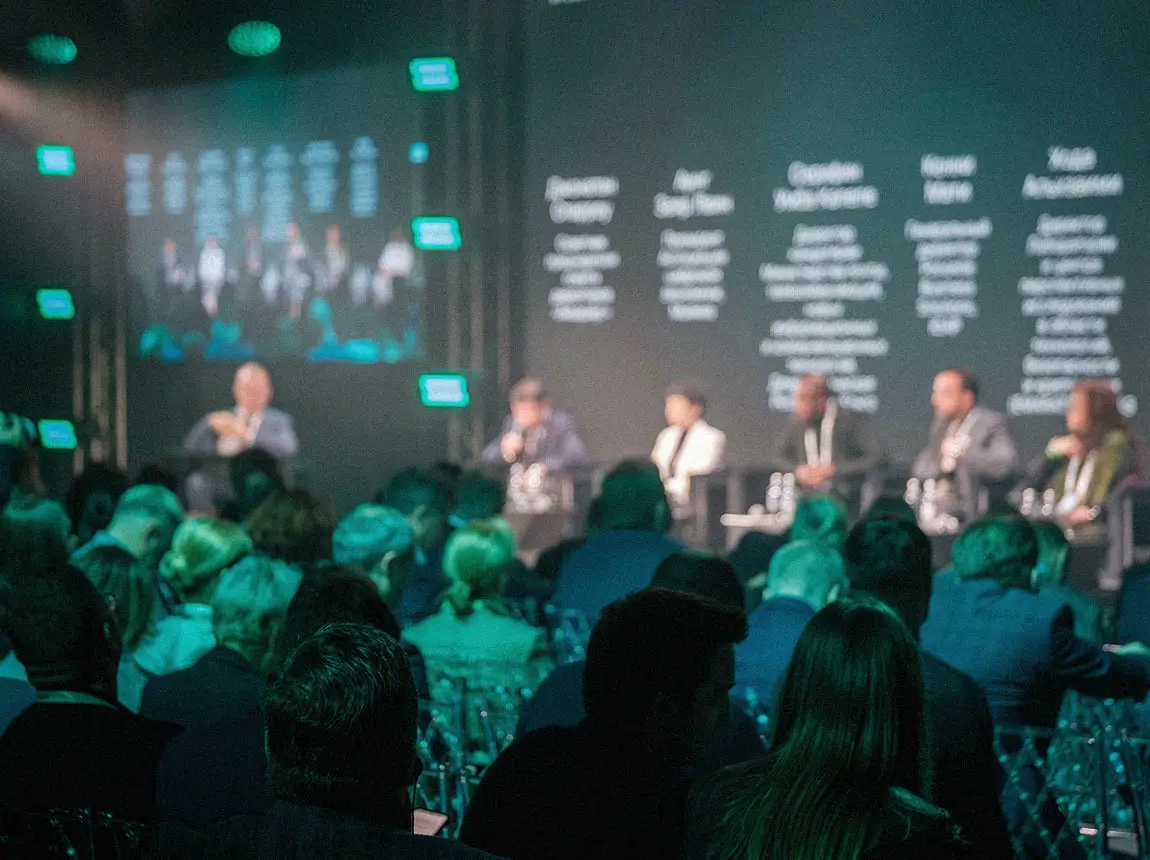 A room full of executives listening to a panel discussion of top tech leaders.