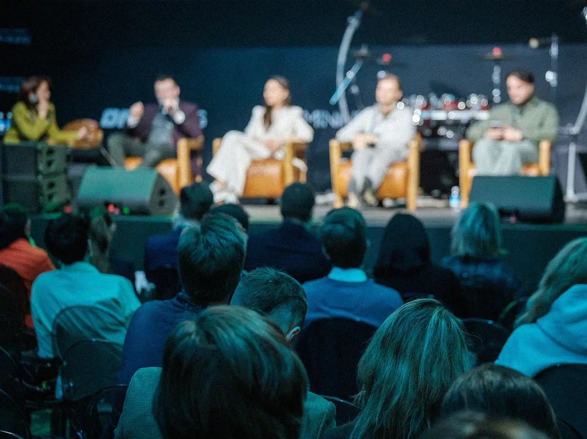 A room full of executives listening to a panel discussion of top tech leaders.
