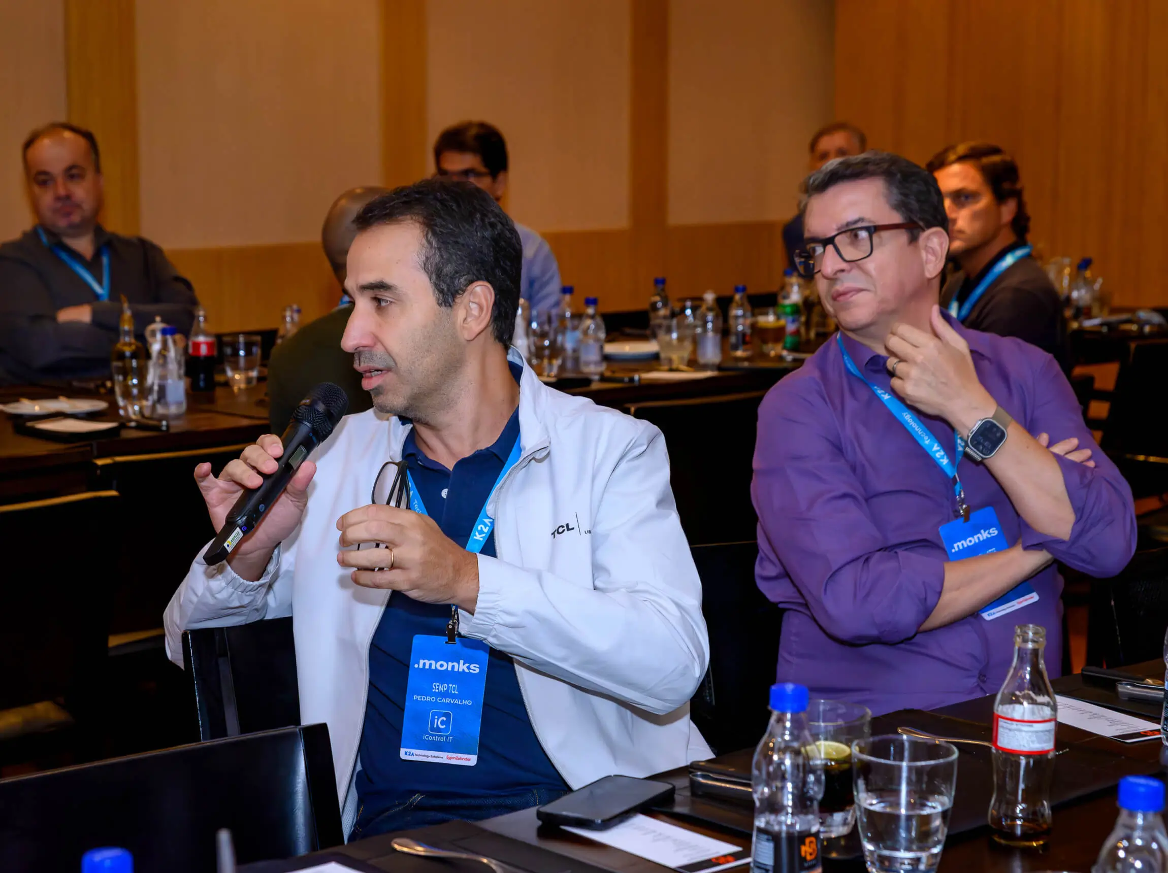 At an exclusive executive event by Monks, a CTO holds a mic and is asking a question to the panel during an engaging discussion about AI.