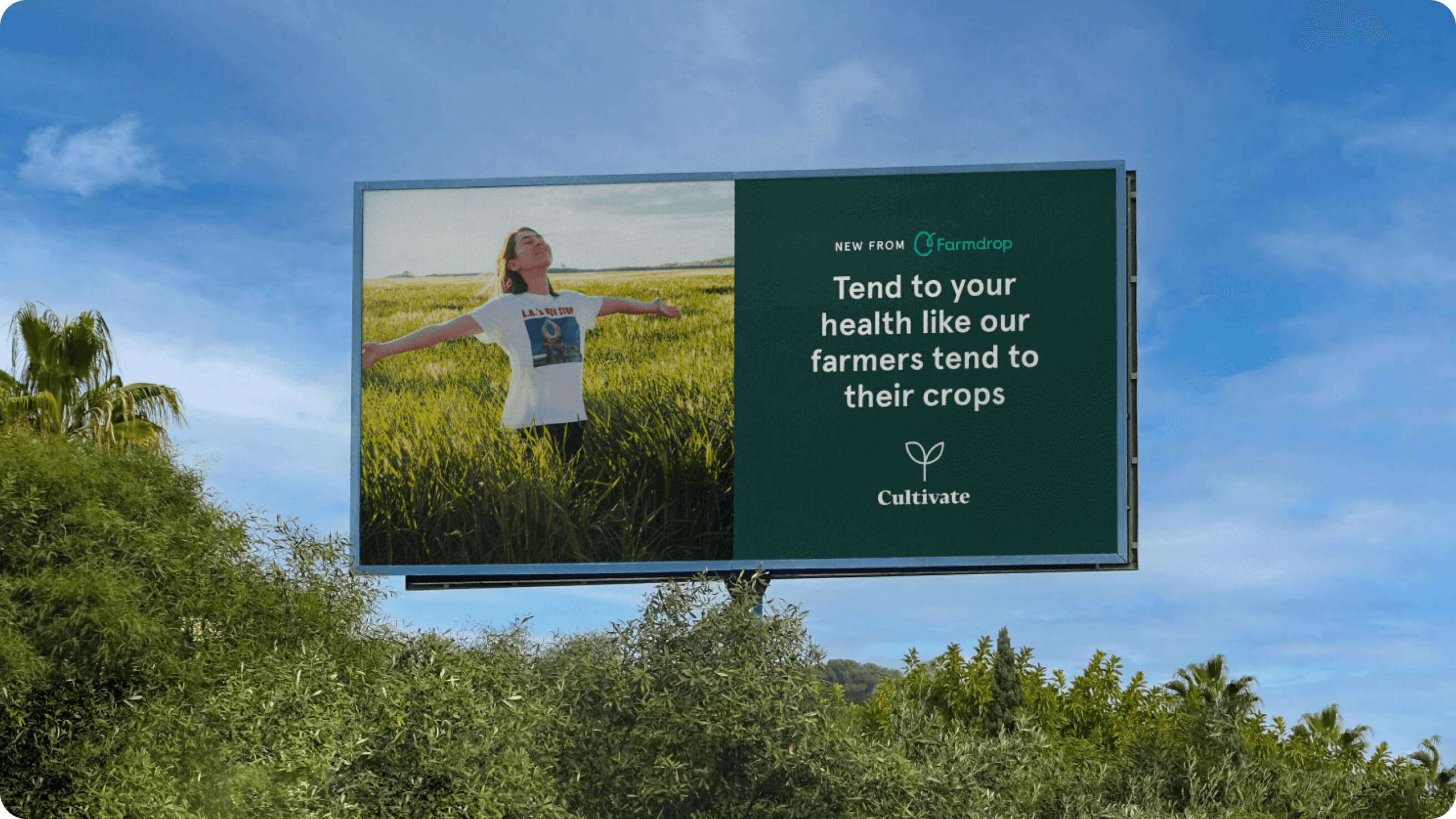 Billboard in a green luscious area. On the billboard it reads "new from Farmdrop — tend to your health like our farmers tend to their crops" Cultivate." There is also a person, arms outstretched in a field feeling the sun on their face.