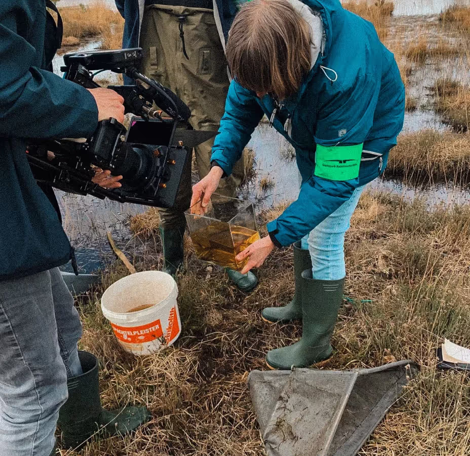 A behind the scenes look with a cameraman and one of the main characters.