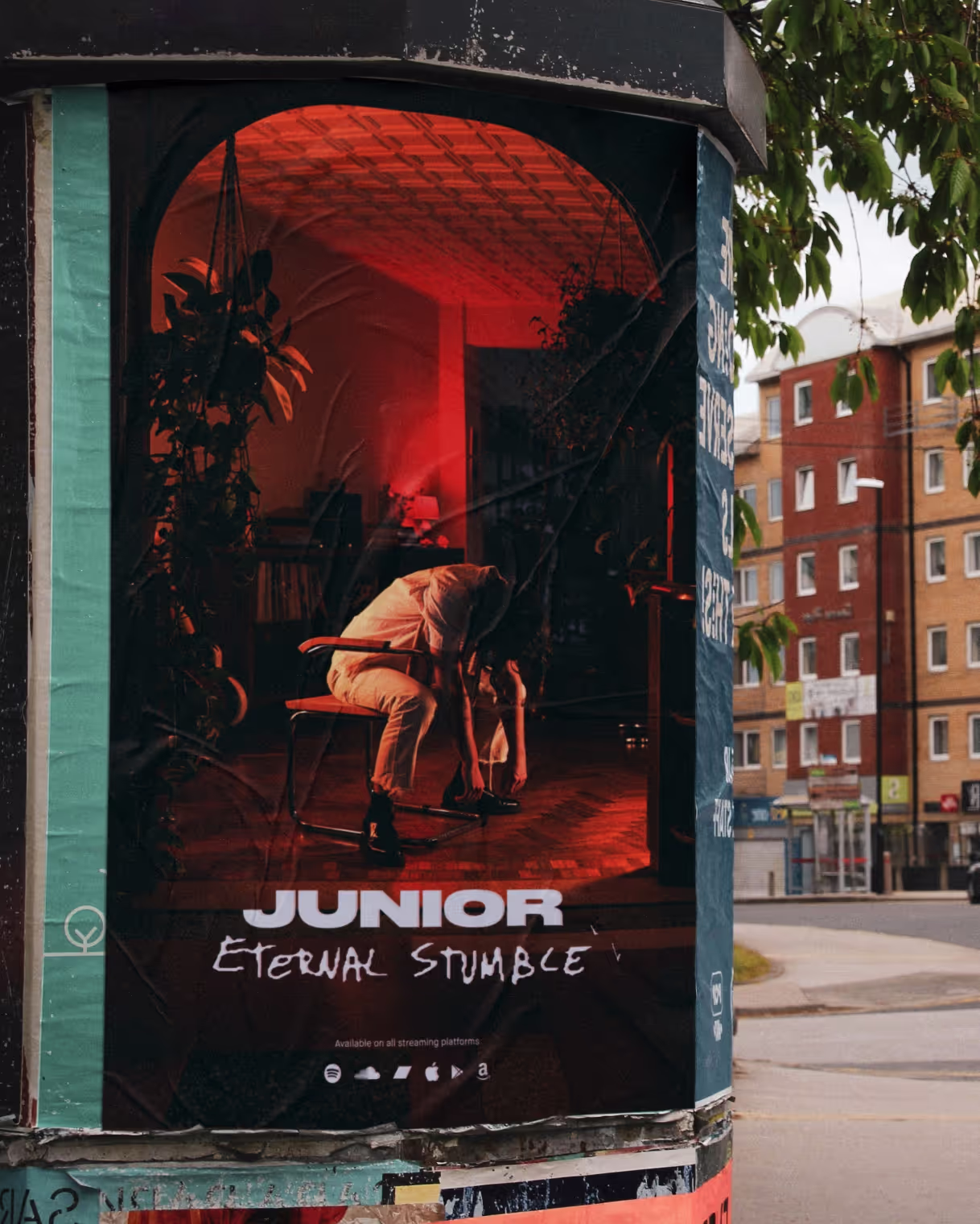 A poster with the album artwork pasted on a pole in a street.