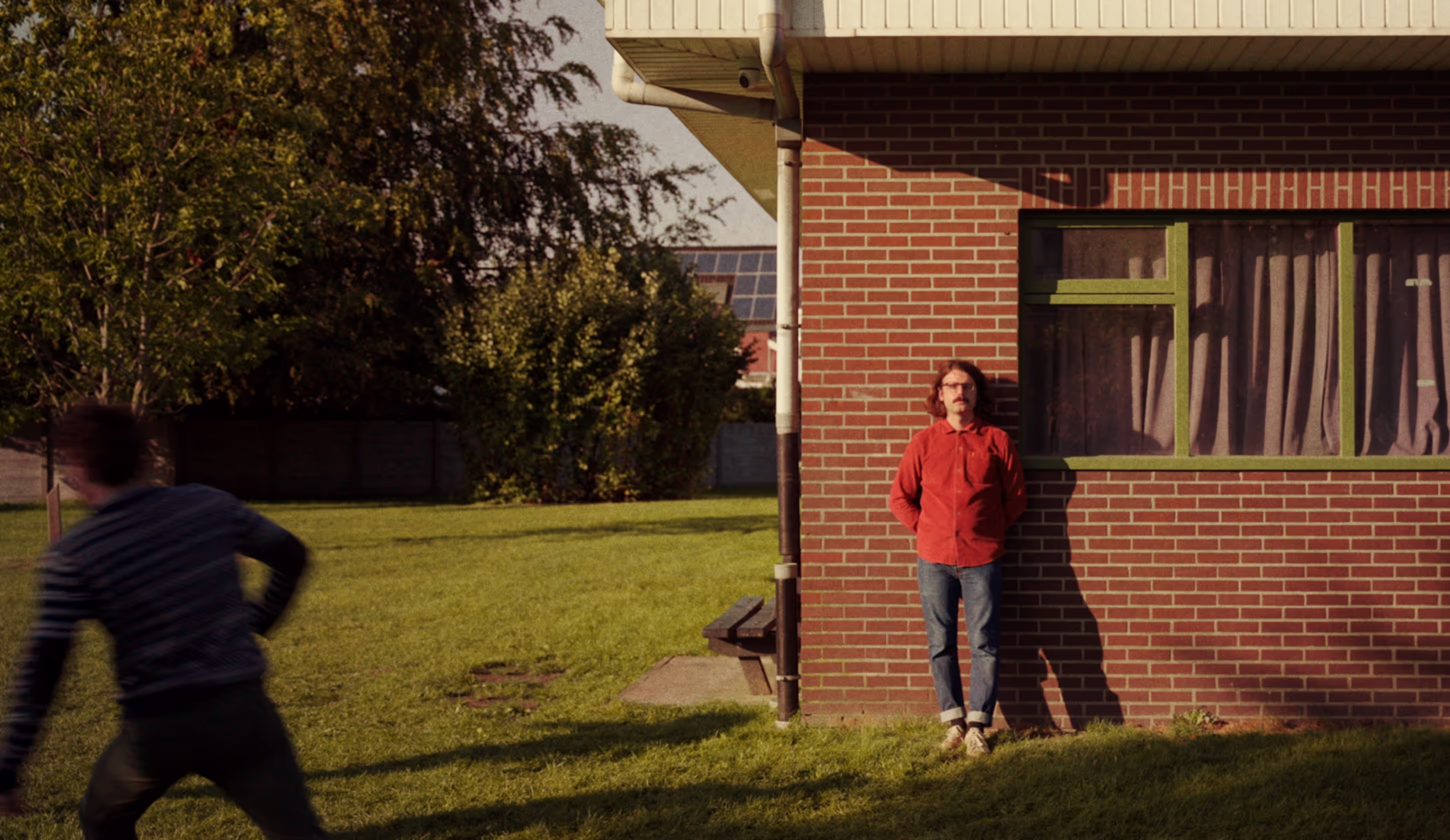 Man leaning against a wall, movement in front.