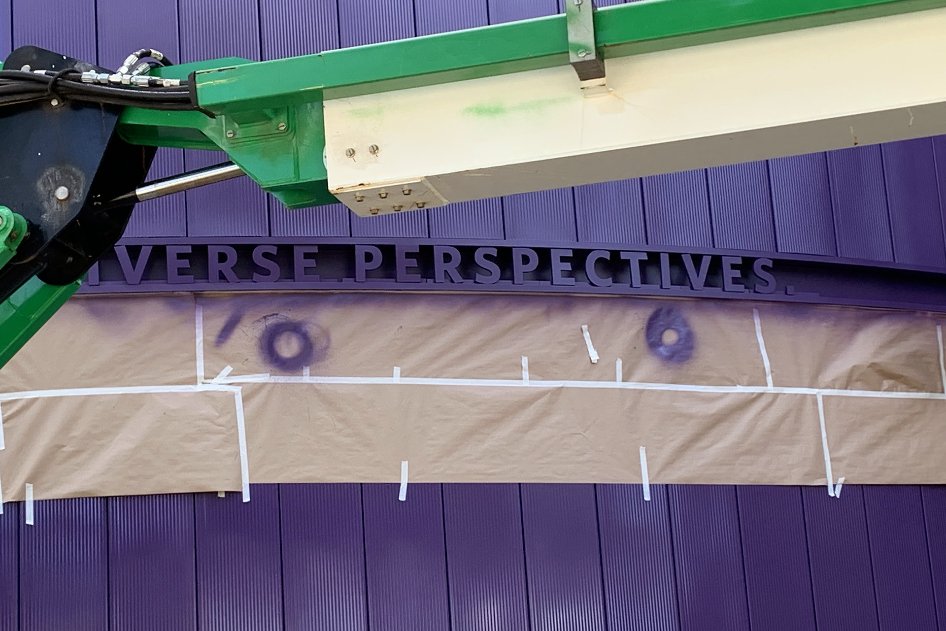 Painters working on purple curtain wall