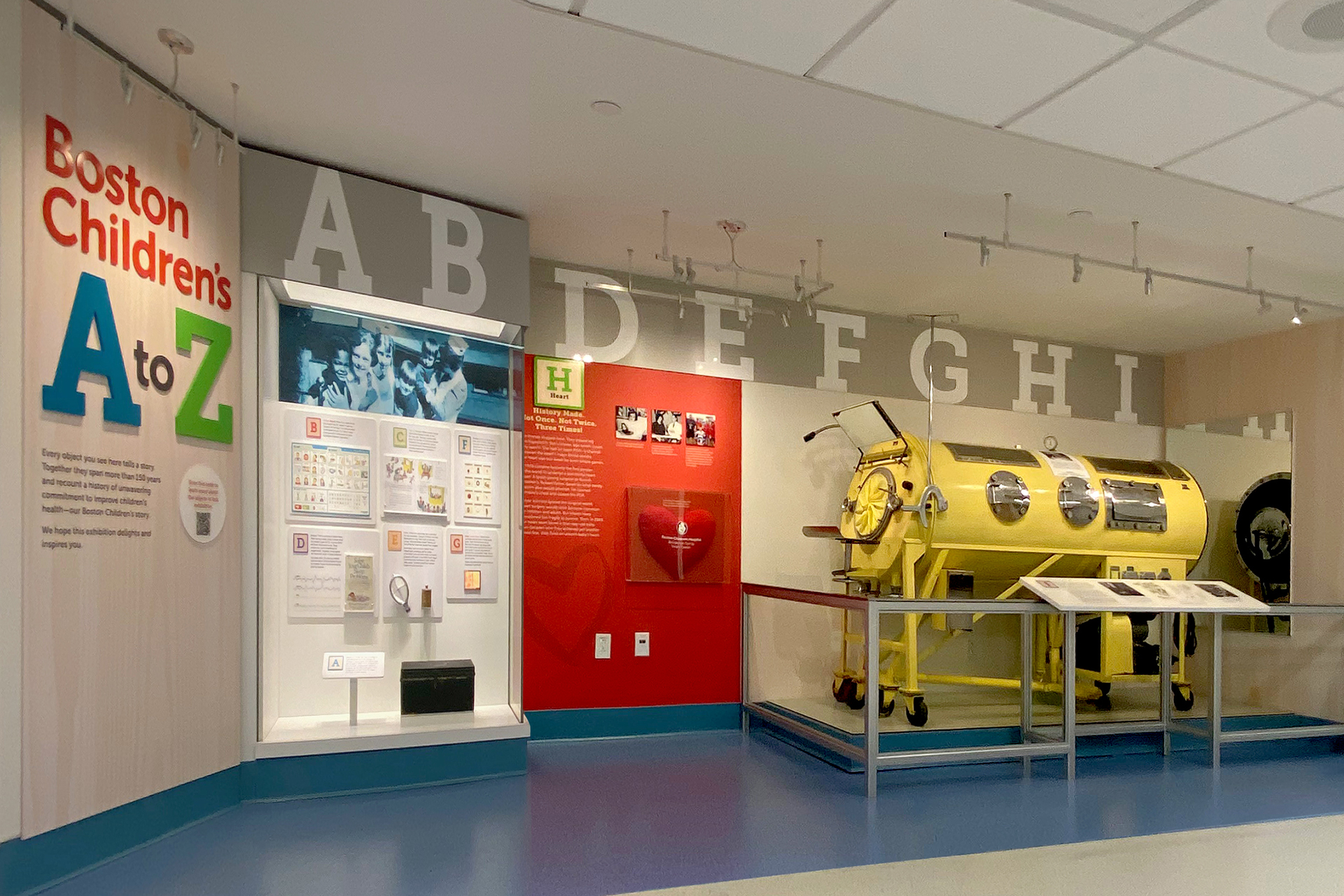 string of letter blocks A to I with artifacts and stories beneath them; exhibit title panel is on the left