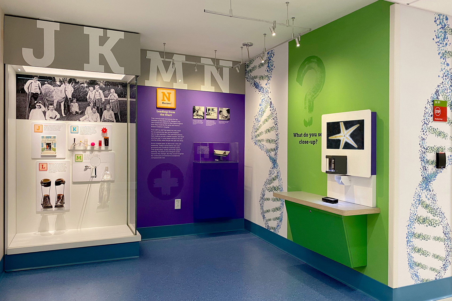 string of letter blocks J to N with artifact case and computer station