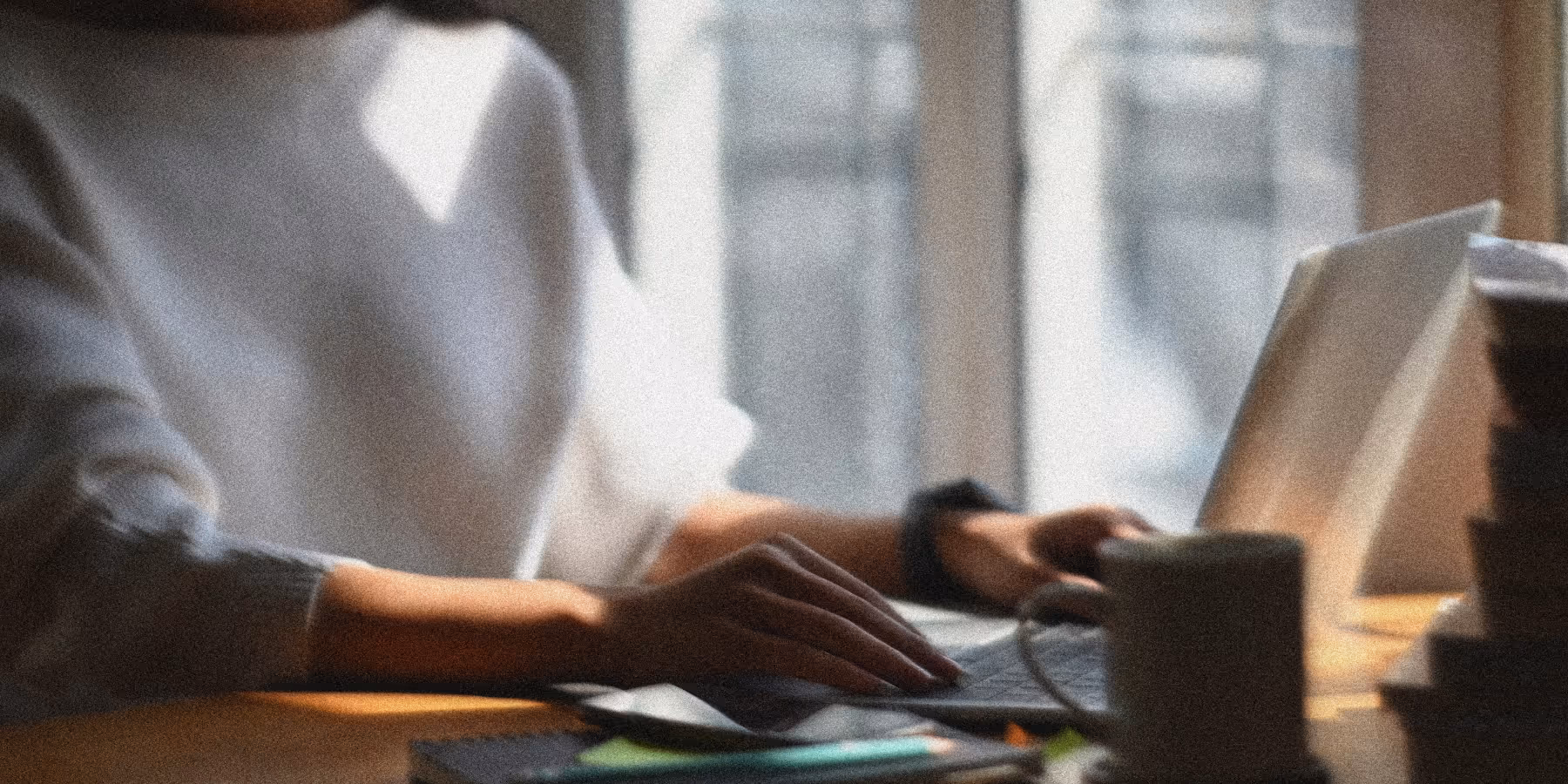 Person typing on a laptop in an office. Cybersecurity platform UX designed for acquisition and scale.