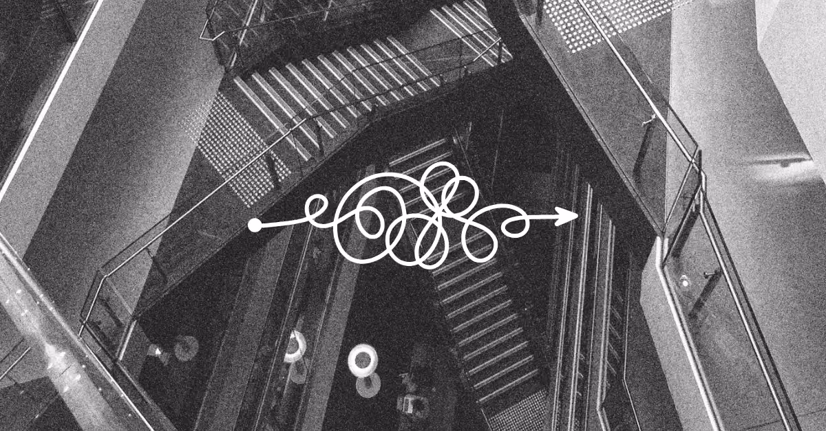 Black-and-white photo of an industrial staircase viewed from above, with a white squiggly line and arrow graphic across the centre suggesting a messy path forward.