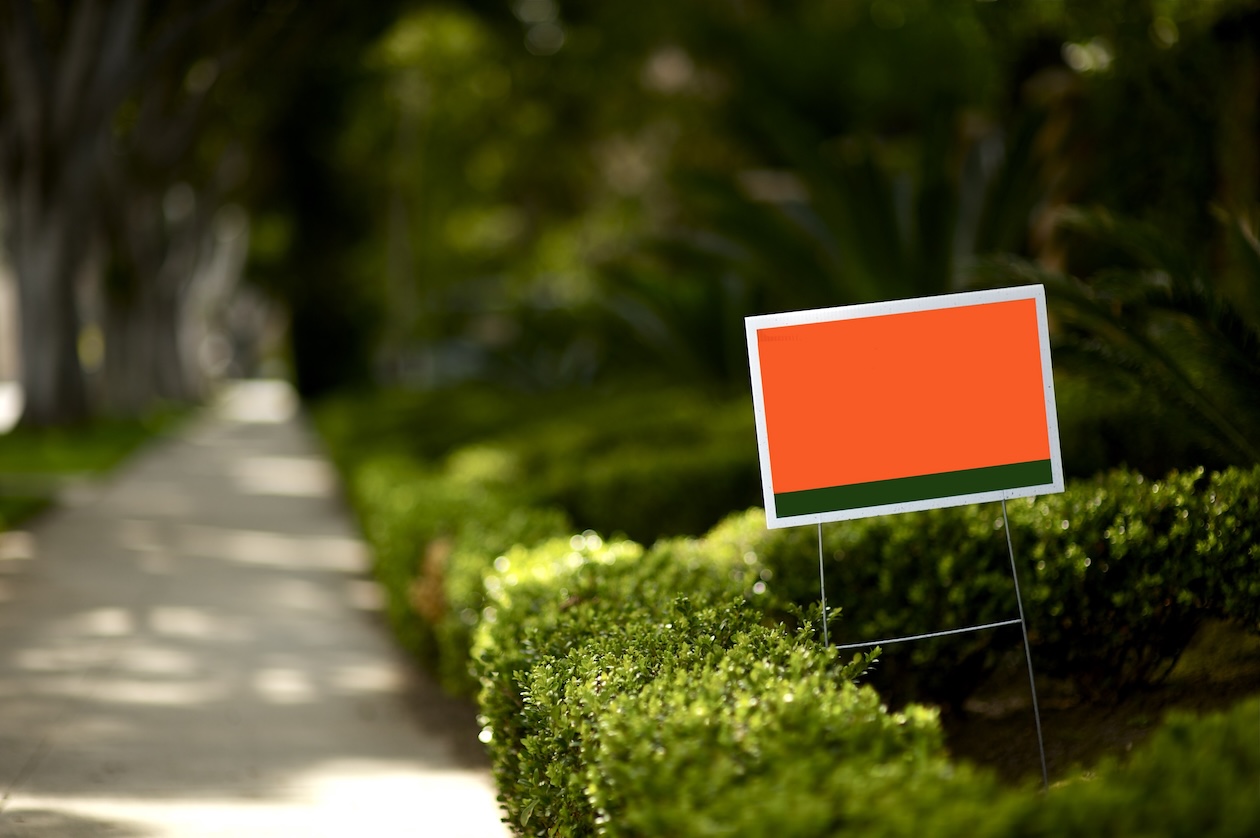 Blank yard sign displayed on a grassy lawn with a metal frame.