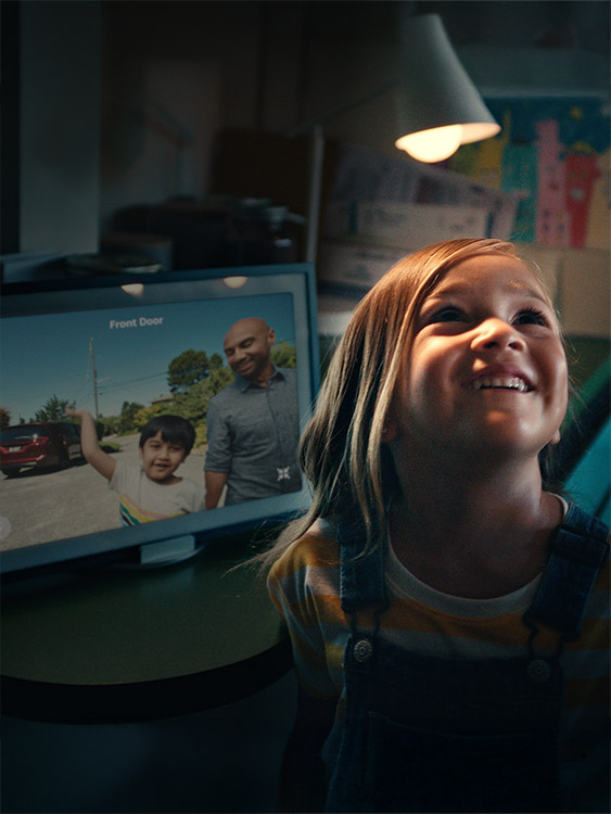 A girl smiles as two visitors are shown in the Amazon Alexa door camera display