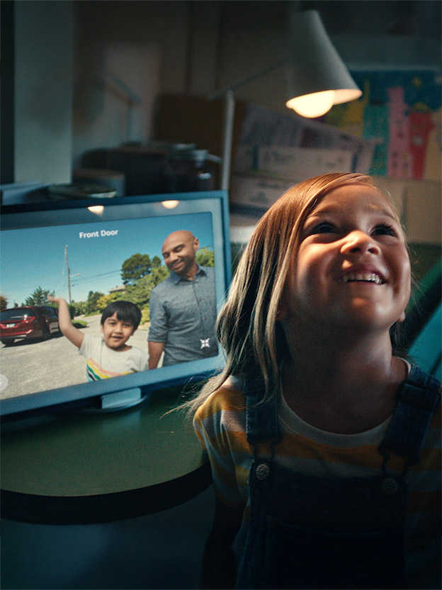 A girl smiles as two visitors are shown in the Amazon Alexa door camera display
