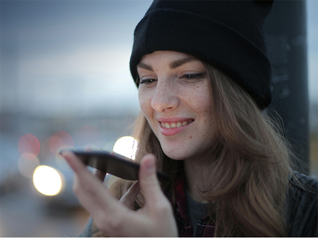 A woman uses the AI voice interface on her phone