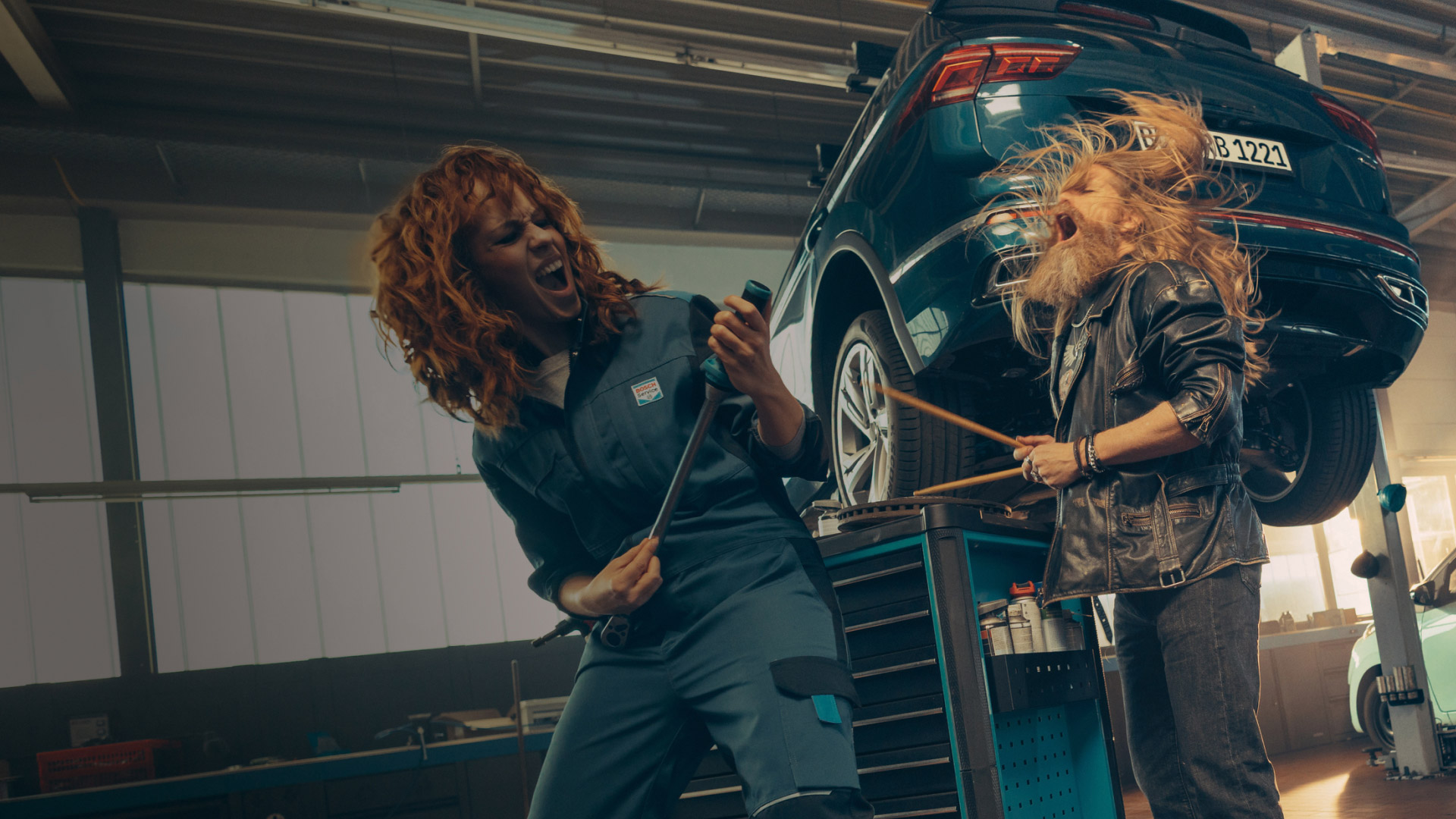 A Bosch Car Service mechanic and customer rocking out together