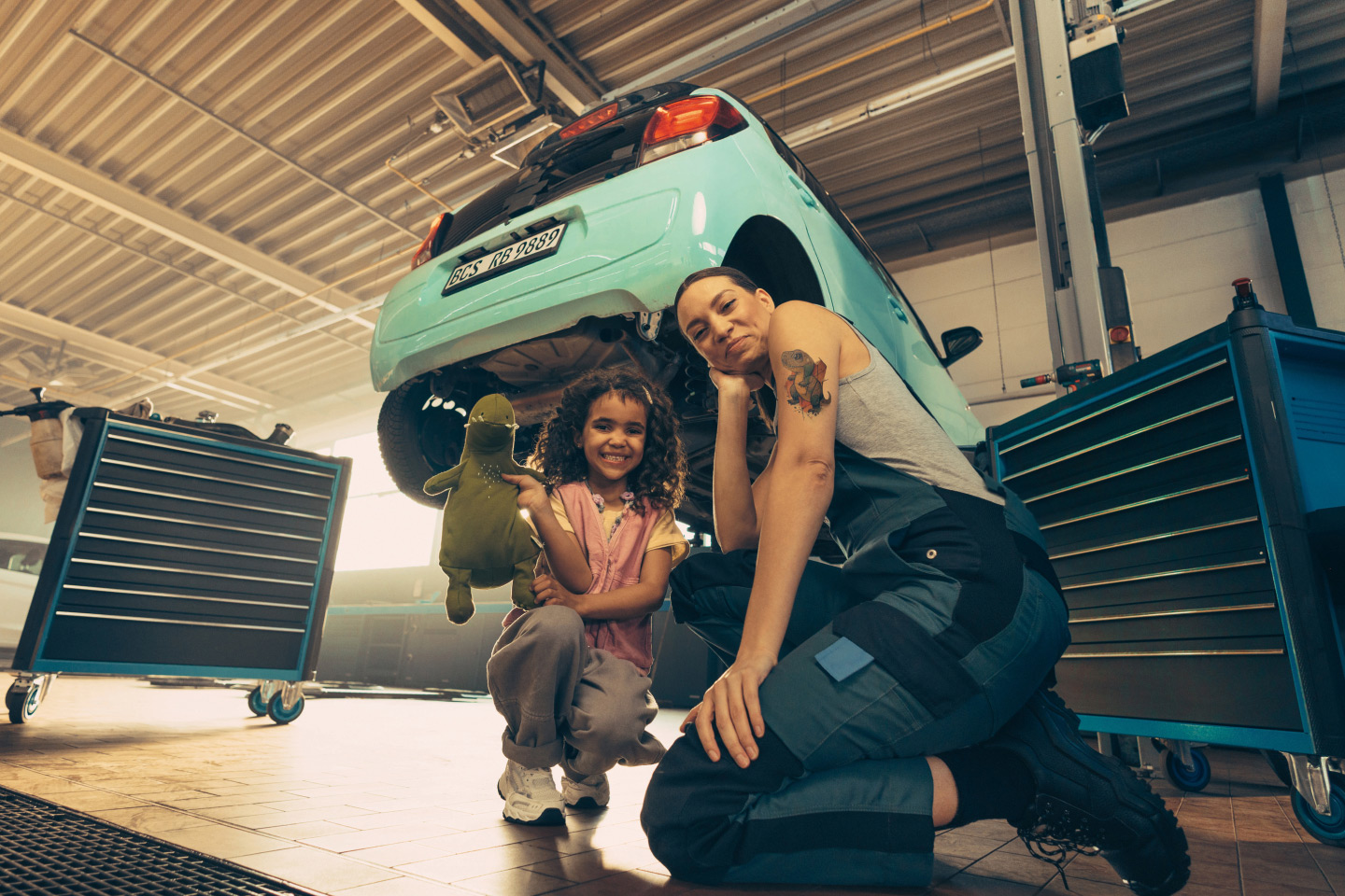 A mechanic and a little girl share their love of dinosaurs