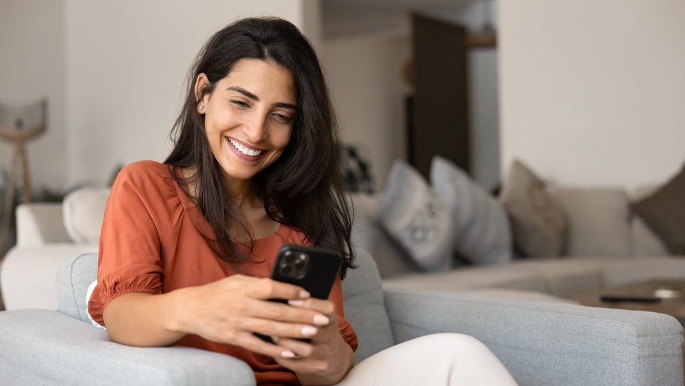 Mujer usando una app para enviar dinero desde su celular.