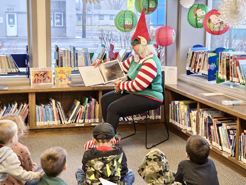 Elf Marlene Clark reads to children at the Meadows Valley Library. Photo credit: Rachel Reynaga.