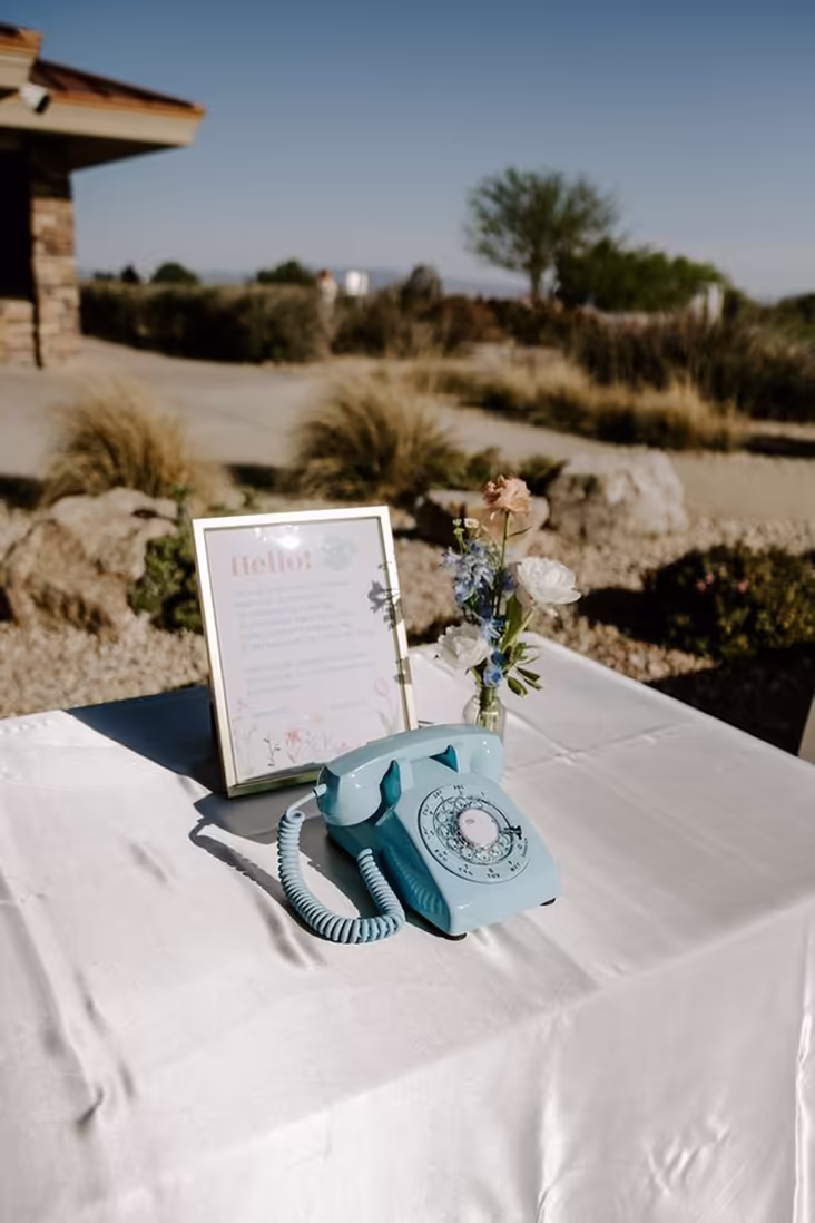 Blue phone audio guestbook on an outdoor reception table