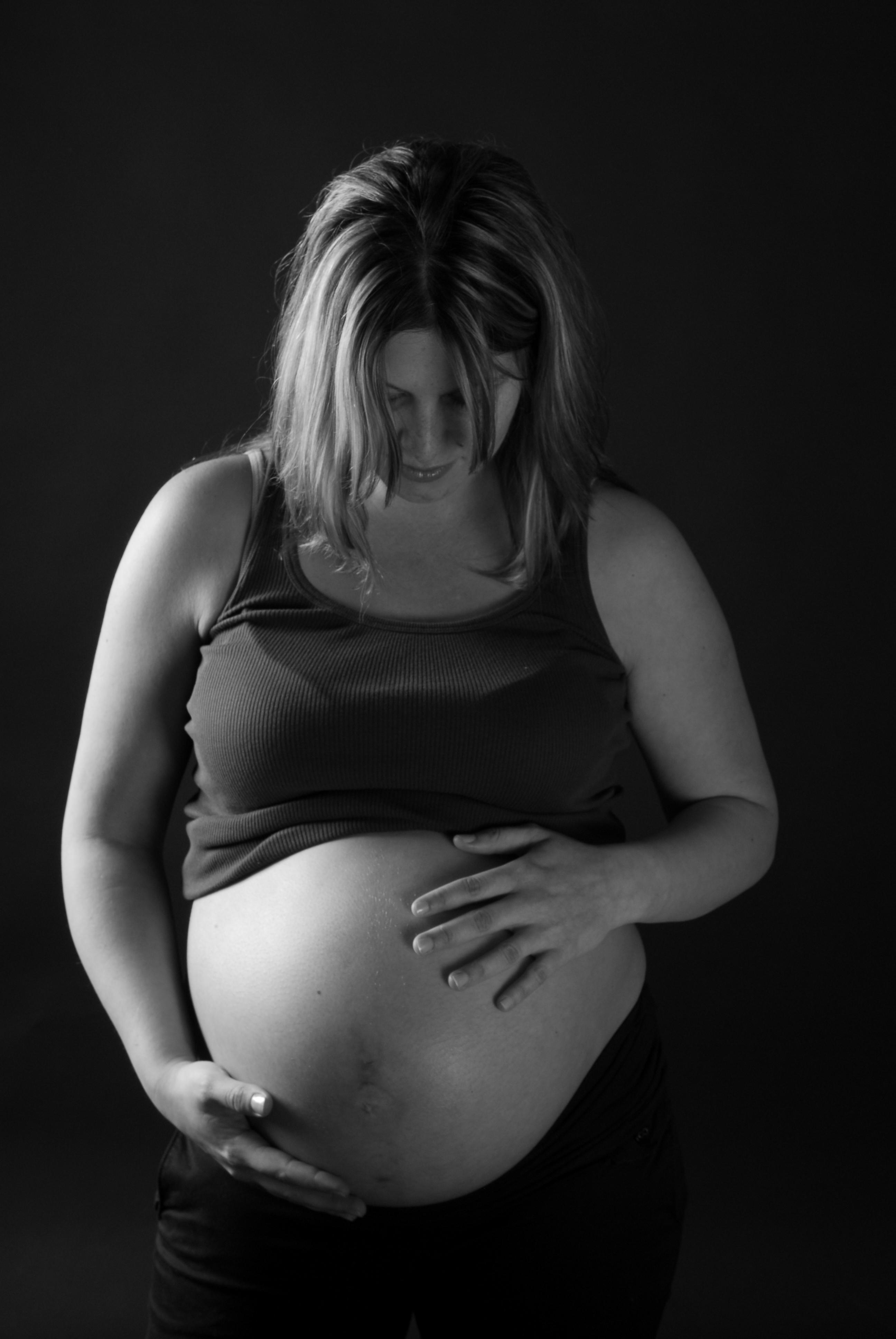 Expectant mother gently holding her belly