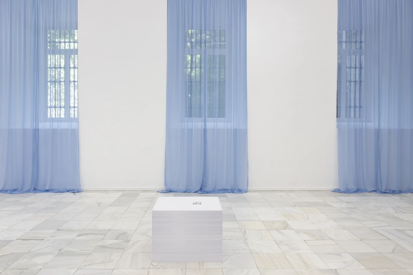 Blue curtains and paper stack in Felix Gonzalez-Torres Sweet Revenge at Museo Reina Sofia